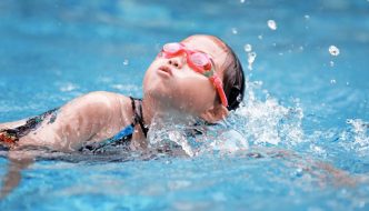 young swimmer girl working on breathing while swimming