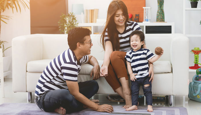 happy mom and dad with young smiling child