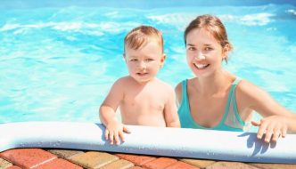 mom with young boy in pool water