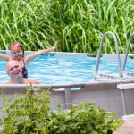 father and daughter excited to be in backyard pool