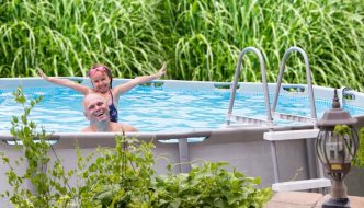 father and daughter excited to be in backyard pool