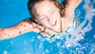 excited young woman swimming in pool