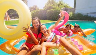 group of preteen friends on floats in pool