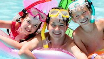 excited children in pool on floats