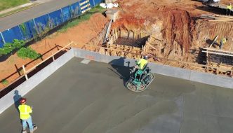 combs concrete crew flattening fresh concrete surface