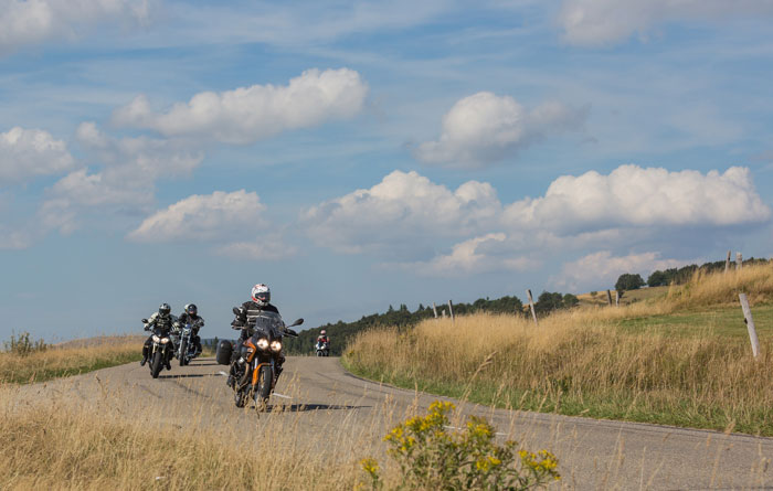 group of motorcyclists riding on the highway