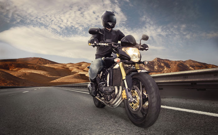 motorcycle on highway asphalt with hills in background