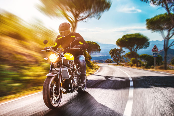 motorcyclist riding through european roads in mountains