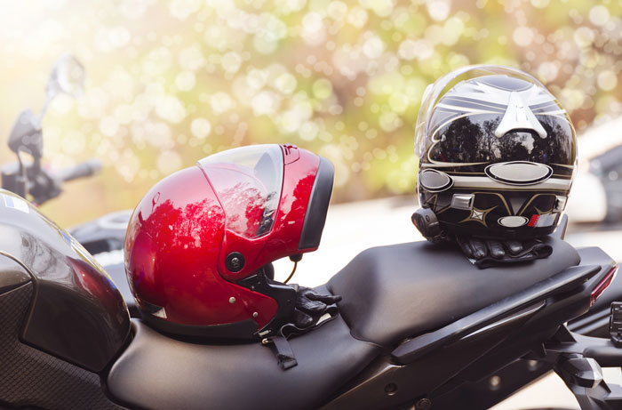 two helmets resting on parked motorcycle