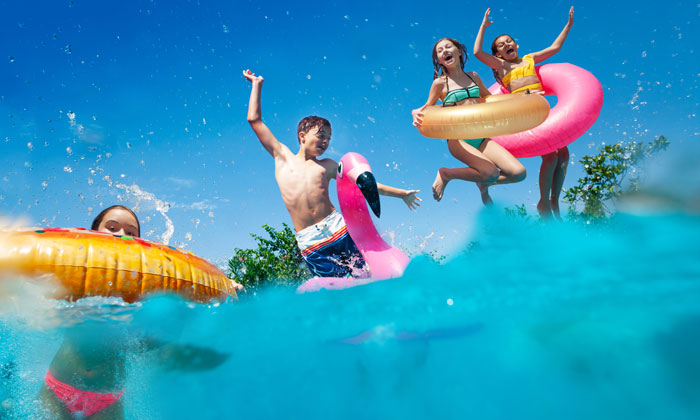 children having abundant fun with pool floats in water children having abundant fun with pool floats in water
